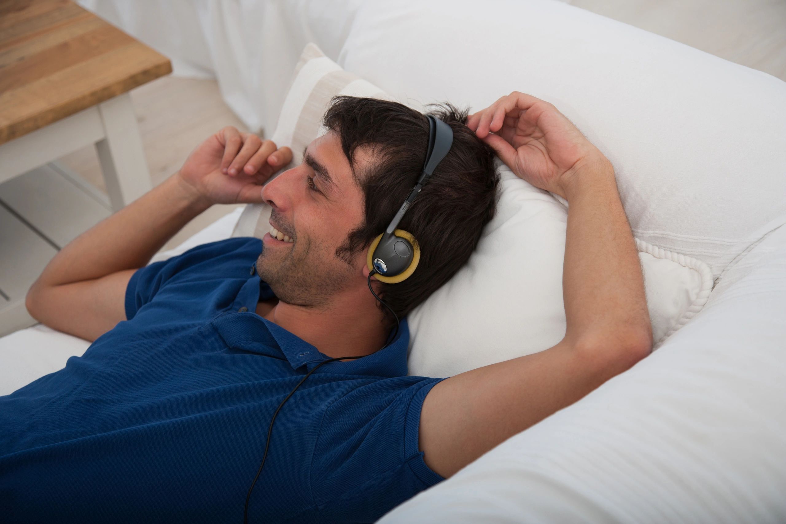 Person relaxing while listening to music with headphones